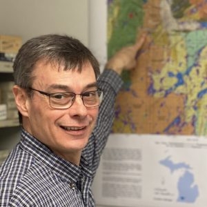 Greg Anderson pointing towards features on a geologic map.