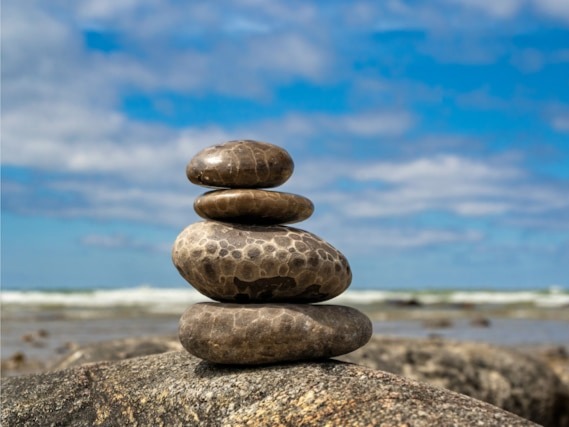 Petoskey stones stacked into a rock cairn on a beach.