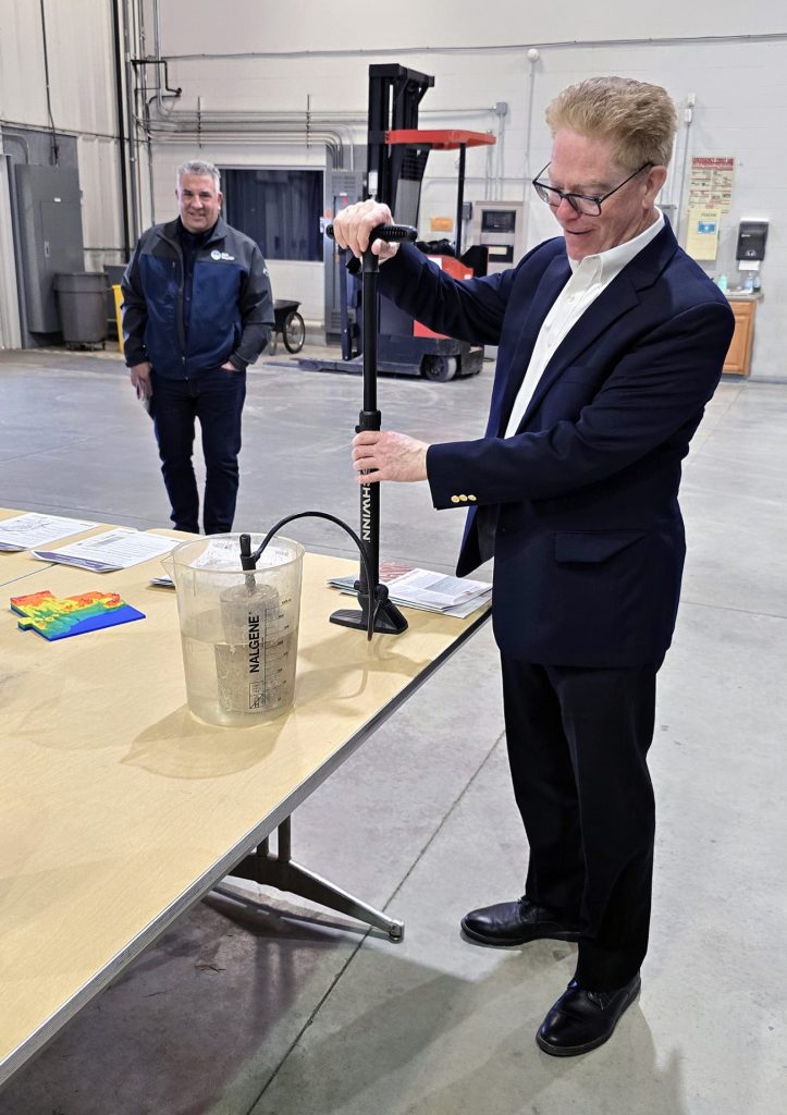 John Walsh uses bicycle pump to force air through porous sandstone.