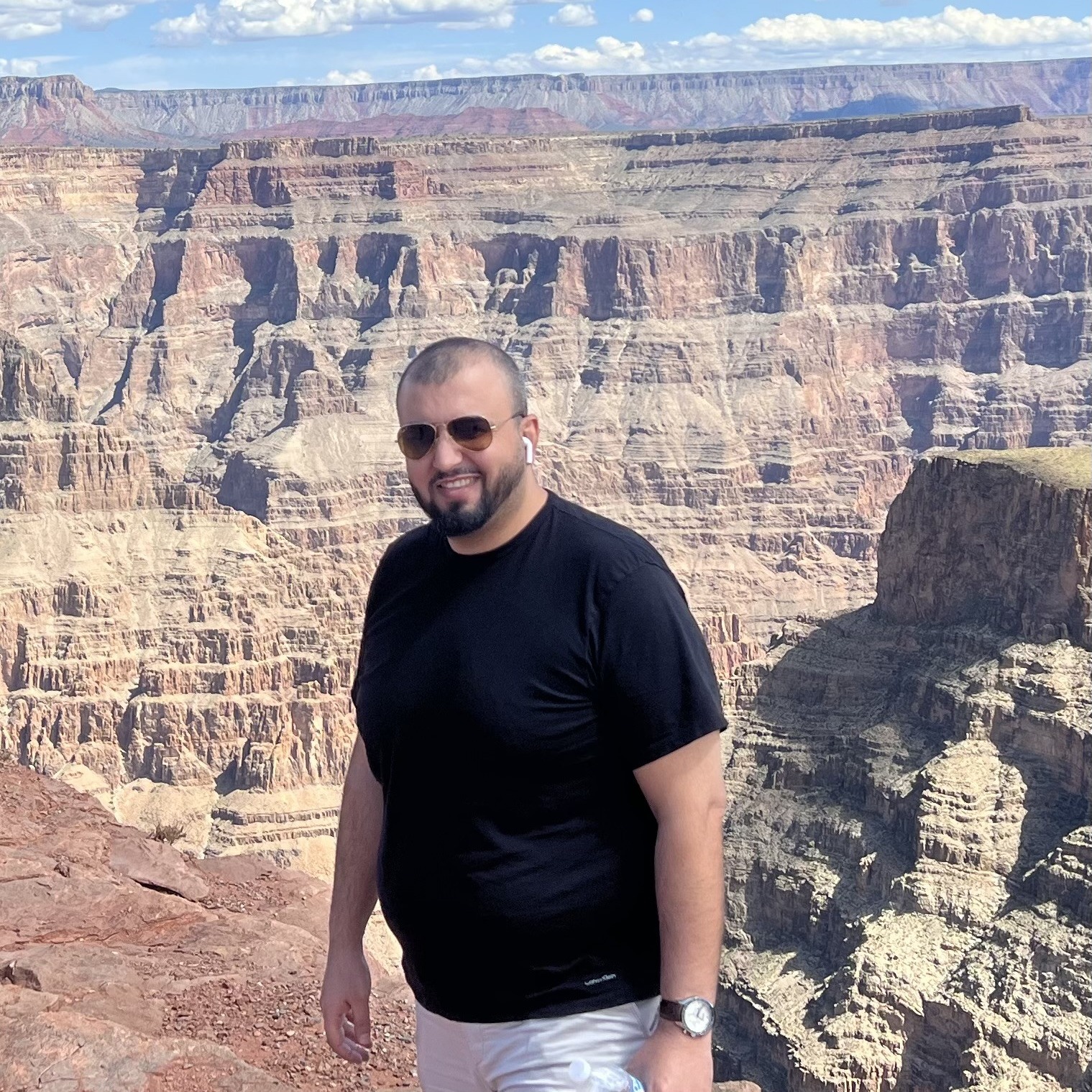 Khalid Omar standing in the foreground with rock cliffs of the Grand Canyon in the background.