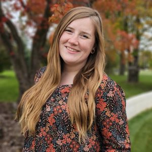 Ashley Scott outdoors with trees and grass in the background.
