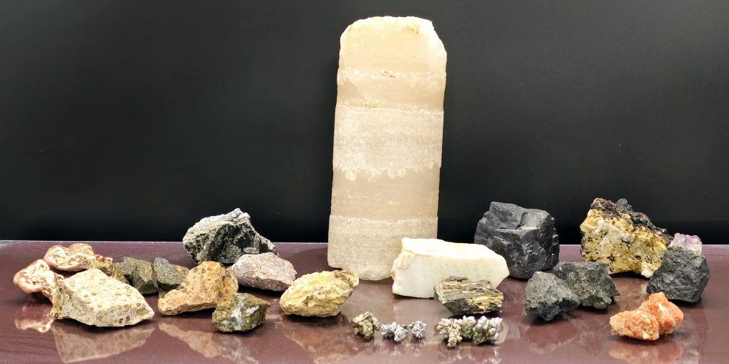 Collection of critical minerals and rocks spread across a table.