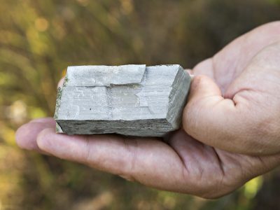 image of a hand holding a small, grey rock